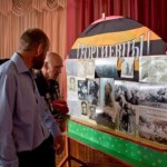 Россов Дмитрий Георгиевич с сыном Россовым Евгением Дмитриевичем - ныне старостой Покровского храма г. Есик у стенда с памятными фотографиями войны